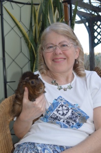 Photo of author Linda Corbett  holding a dark ginger guinea pig.